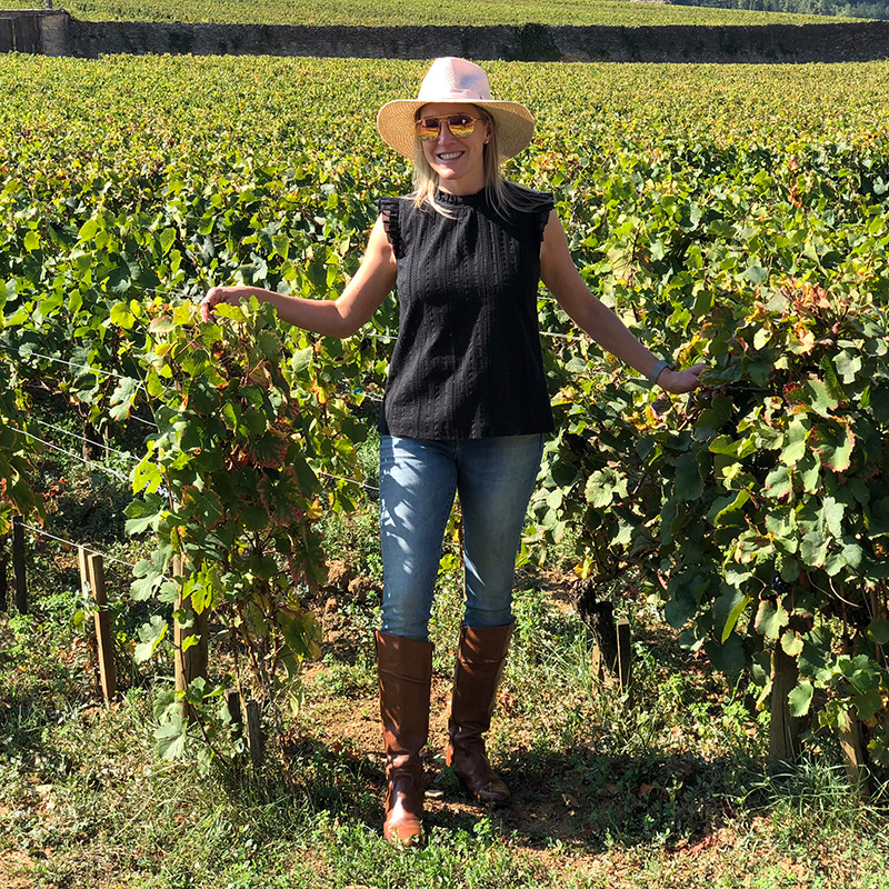 Emily Krueger of 34th Degree Wine Merchant walking through the fields at a vineyard